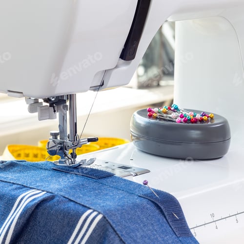 Preview: Sewing machine with striped blue white fabric and thread, pins on background, horizontal
