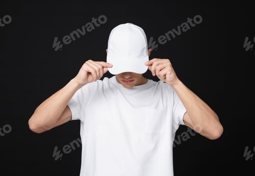 Preview: Young man wearing stylish white baseball hat on black background