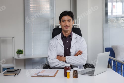 Preview: Male doctor smiling sitting in medical office