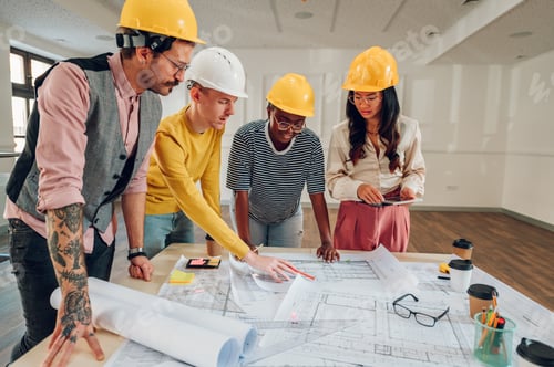 Preview: Multiracial team of architects having a meeting while using blueprints