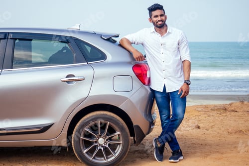 Preview: Indian businessman standing near car outdoors on sea beach summer good day.