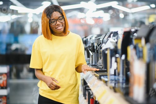 Preview: Smart modern african american female customer choosing coffee machine at electronics store