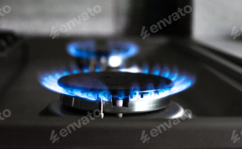 Preview: Close-up of a blue fire from a kitchen stove. two gas burners with a burning flame. economy concept