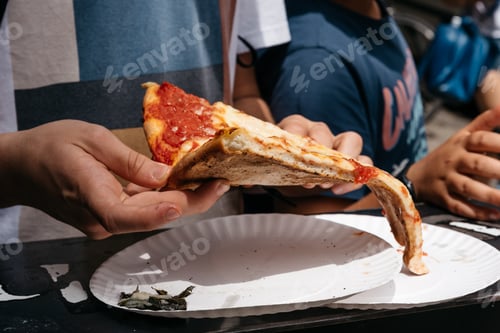 Preview: Young male eating traditional italian pizza on paper plate