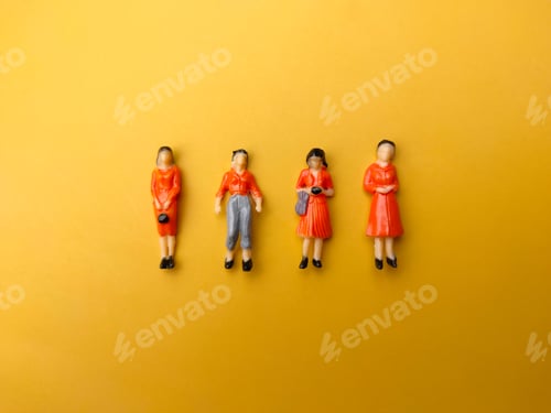 Preview: Miniature people are neatly arranged on a yellow background.