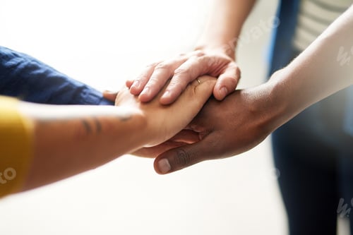 Preview: Closeup shot of a group of businesspeople joining their hands together in unity