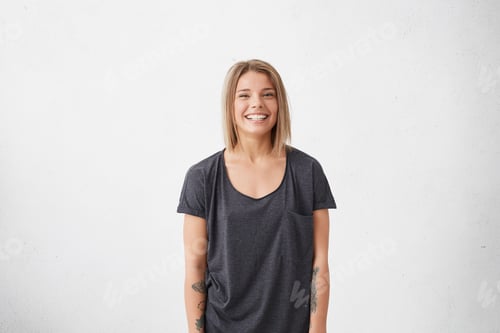 Smiling Young Woman Posing Against a White Wall