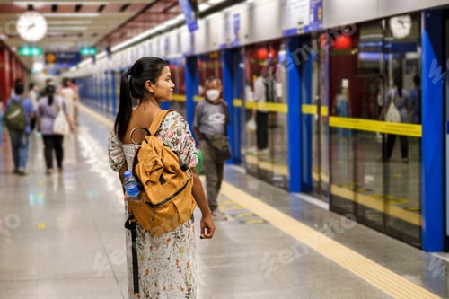 Preview: Asian woman tourist waiting for skytrain at railway station platform in the city Bangkok Thailand