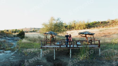 Preview: Couple enjoying a glass of wine on a pontoon in a rural are