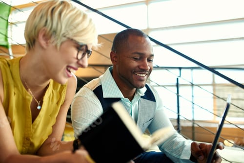 Preview: Two creative millenial small business owners working on social media strategy in a staircase