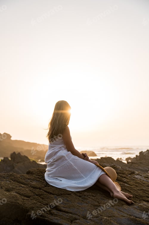 Preview: Unrecognizable woman on rocky seashore
