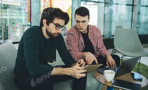 Preview: Serious colleagues with clipboard discussing business