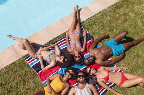 Preview: Diverse group of friends sunbathing together by pool on a sunny day