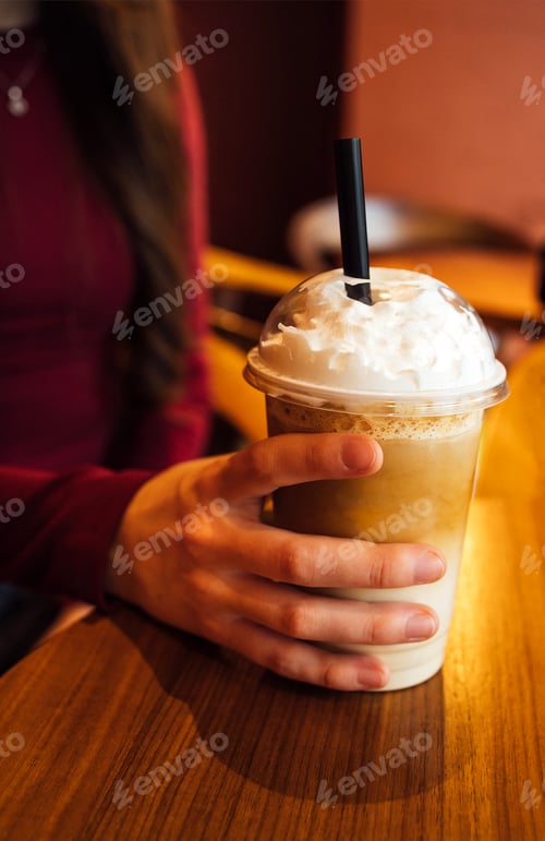 Preview: A young girl with long dark hair and casual clothes with a glass of drink