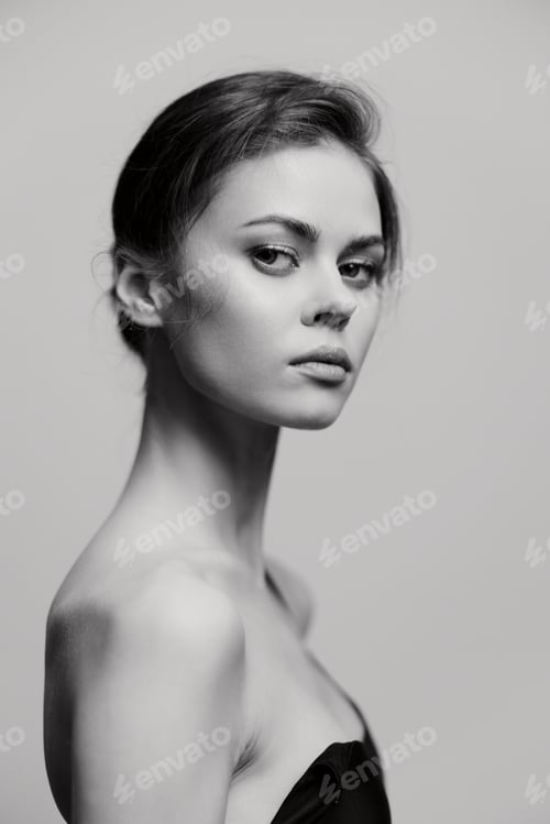 Preview: Elegant young woman with a sophisticated look, showcasing her profile against a soft gray backdrop