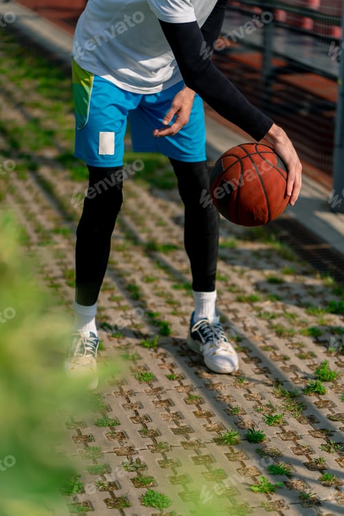 Preview: tall guy basketball player walks down the park path to the basketball court