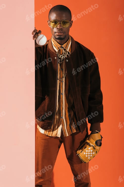 Preview: confident african american man holding baseball glove and ball, looking at camera