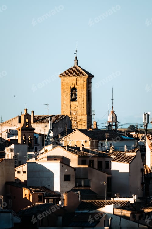 Preview: Toledo. A charming Spanish cityscape featuring a brick bell tower rising above tiled rooftops