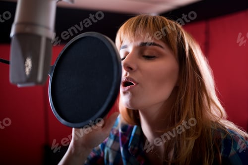 Preview: Female with microphone recording a voice for dubbing in music studio