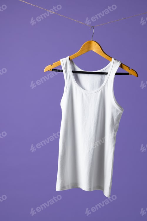 Preview: Tshirt hanging on coat hanger and copy space on purple background