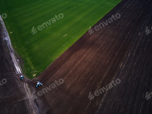 Preview: Aerial view of a modern green tractor plowing dry agricultural field