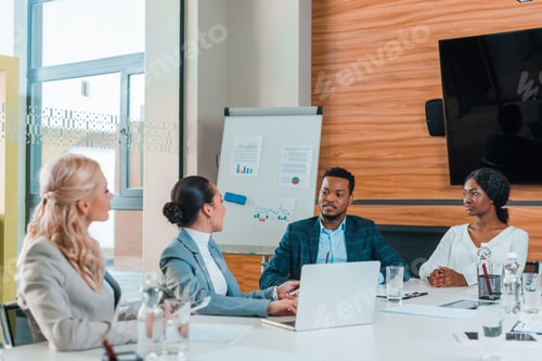 Preview: young multicultural businesspeople having meeting while sitting in conference hall