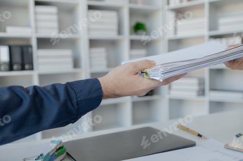 Preview: Businesspeople hands working in stacks of paper files for searching, business employee working in st