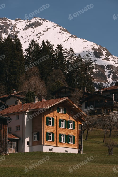 Preview: Traditional swiss chalet nestled in the alps during springtime