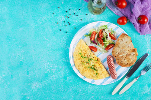 Preview: Fried omelette with sausage and salad. Delicious breakfast with eggs and toast