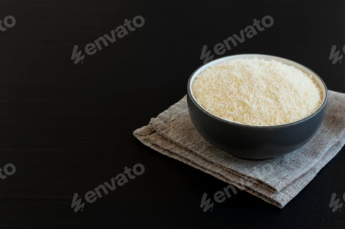 Preview: Organic Grated Parmesan Cheese in a Bowl, side view. Copy space.