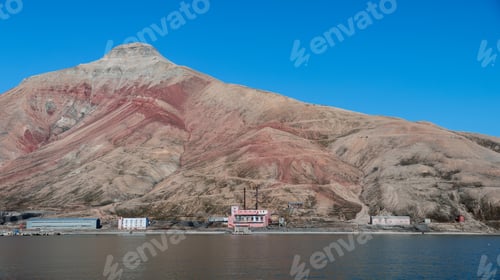 Preview: Abandoned buildings by the shore beneath the colorful mountains of Pyramiden in Svalbard
