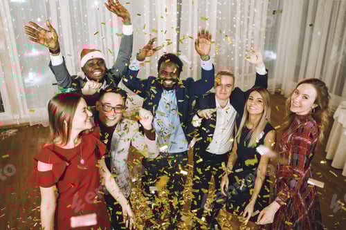 Preview: Group of diverse people celebrate Christmas with confetti.