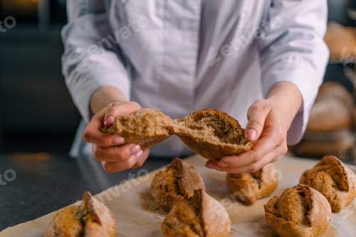 Preview: baker showing hot cut freshly baked crispy and puffy bread bun bakery