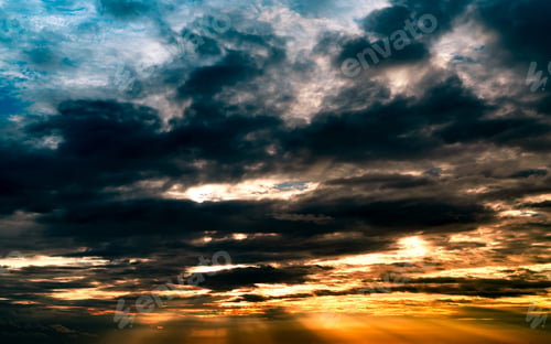 Preview: God light. Dramatic dark cloudy sky with sun beam. Yellow sun rays through dark and gray clouds.