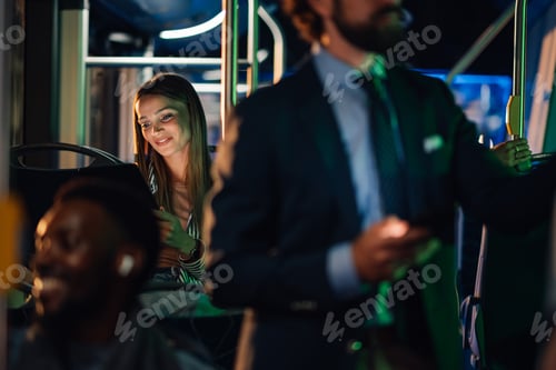 Preview: Young woman using tablet while riding public transport at night