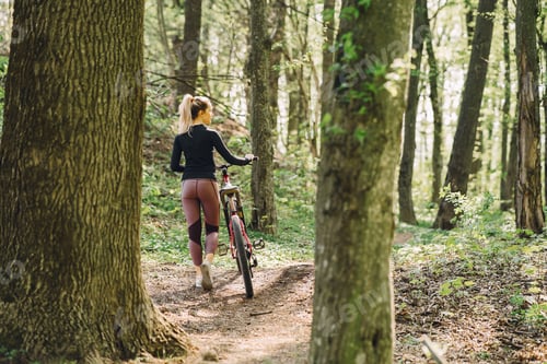 Preview: Woman riding a mountain bike in the forest