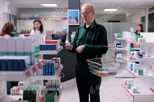 Preview: Elderly man looking at pills package during medication shopping