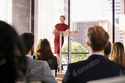 Preview: Young woman leaning on lectern presenting business seminar
