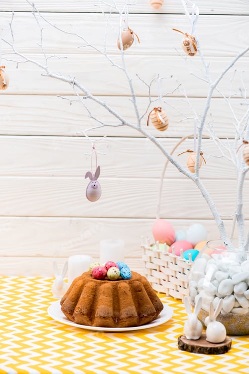 Preview: Easter cake with painted eggs and ceramic rabbits on table