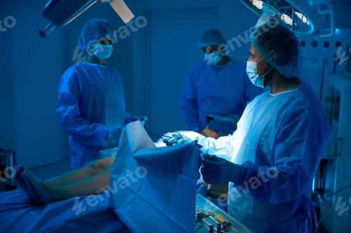 Preview: Surgeons team conducting surgical procedure in operating theater
