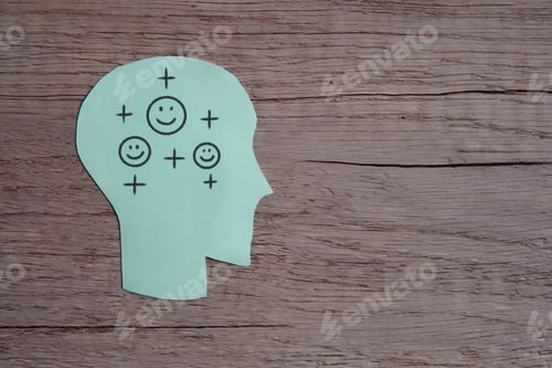 Preview: A green paper cut-out of a human head with a smile face and positive icon.