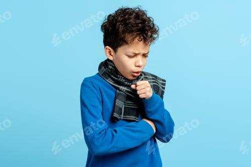 Preview: Sick child with a scarf, coughing and feeling unwell due to a cold or flu