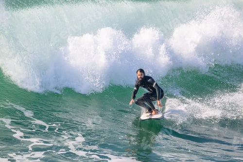 Preview: Male surfer riding a wave on a surfboard near Huntington Beach