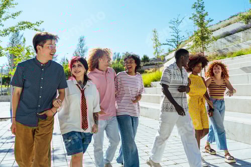 Preview: Multiethnic group of young friends meeting and having fun outdoors