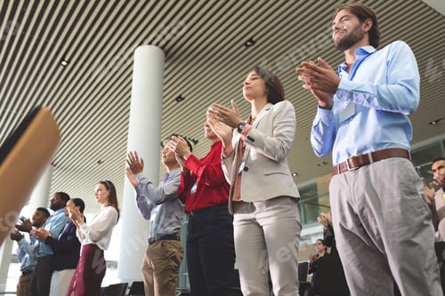 Preview: Business people clapping while standing at a business seminar in office