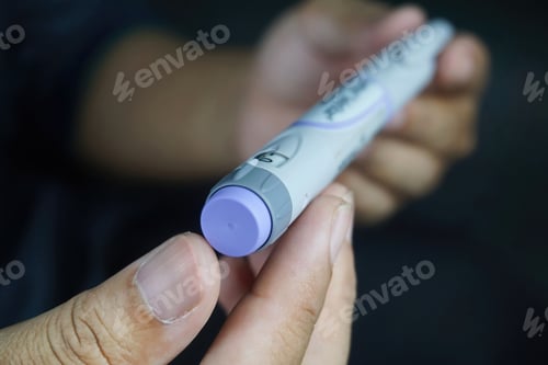 Preview: Closeup of a male hands holding insulin pen - Medical equipment concept