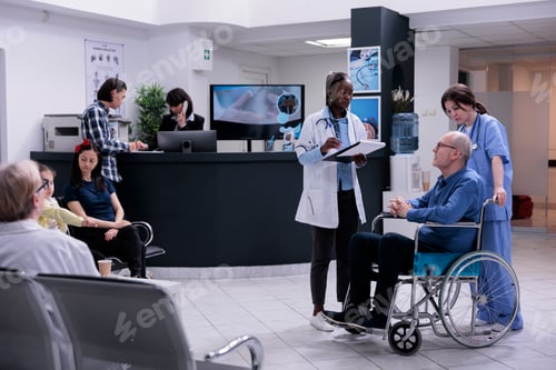 Preview: Retired person using wheelchair being helped by professional nurse talking with african american