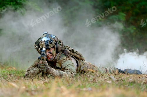 Preview: Beautiful woman soldier lie on ground and point gun to target direction with concept of woman fight