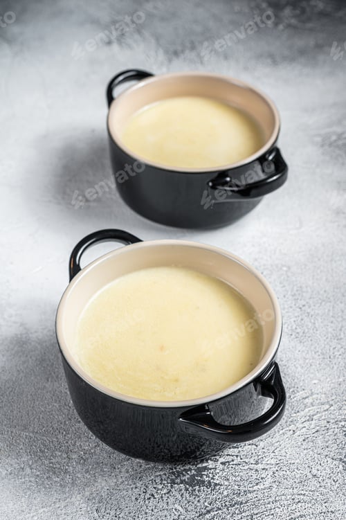 Preview: Homemade potato cream soup in bowls. White background. Top view