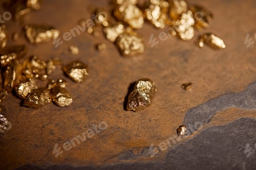 Preview: selective focus of golden stones on grey and brown marble surface
